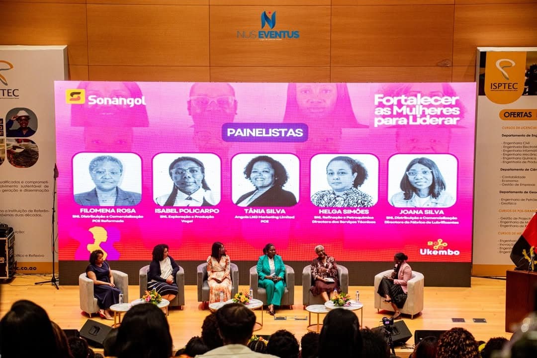 Painel de oradoras numa conferência com ecrã LED ao fundo